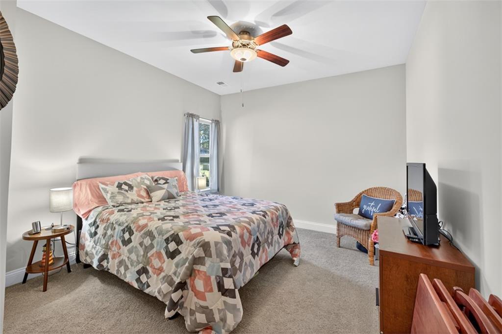 829 River Fall Drive Jefferson, GA 30549 - Photo 33 of 63 a bedroom with a bed and a flat tv screen on a dresser