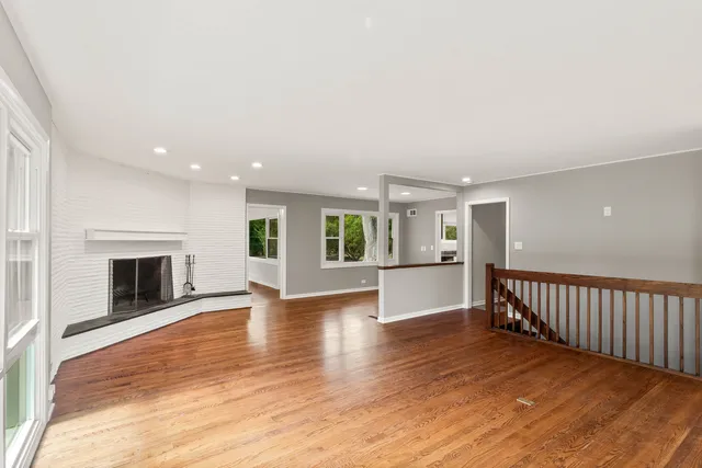 a view of empty room with wooden floor and fireplace