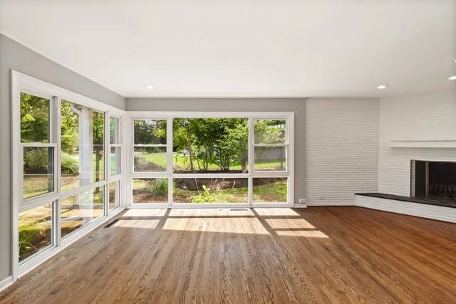 an empty room with wooden floor and fireplace