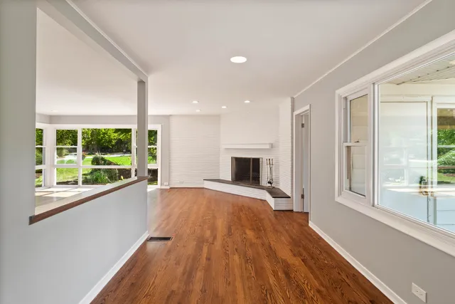 a view of empty room with wooden floor and fireplace