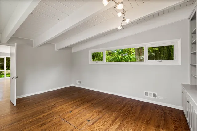 a view of room with wooden floor and windows