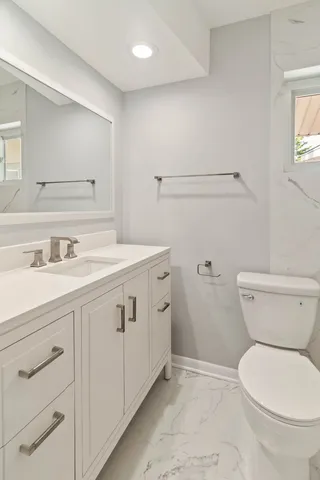 a bathroom with a sink a toilet and a mirror