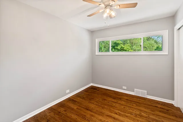 an empty room with a window and a fan