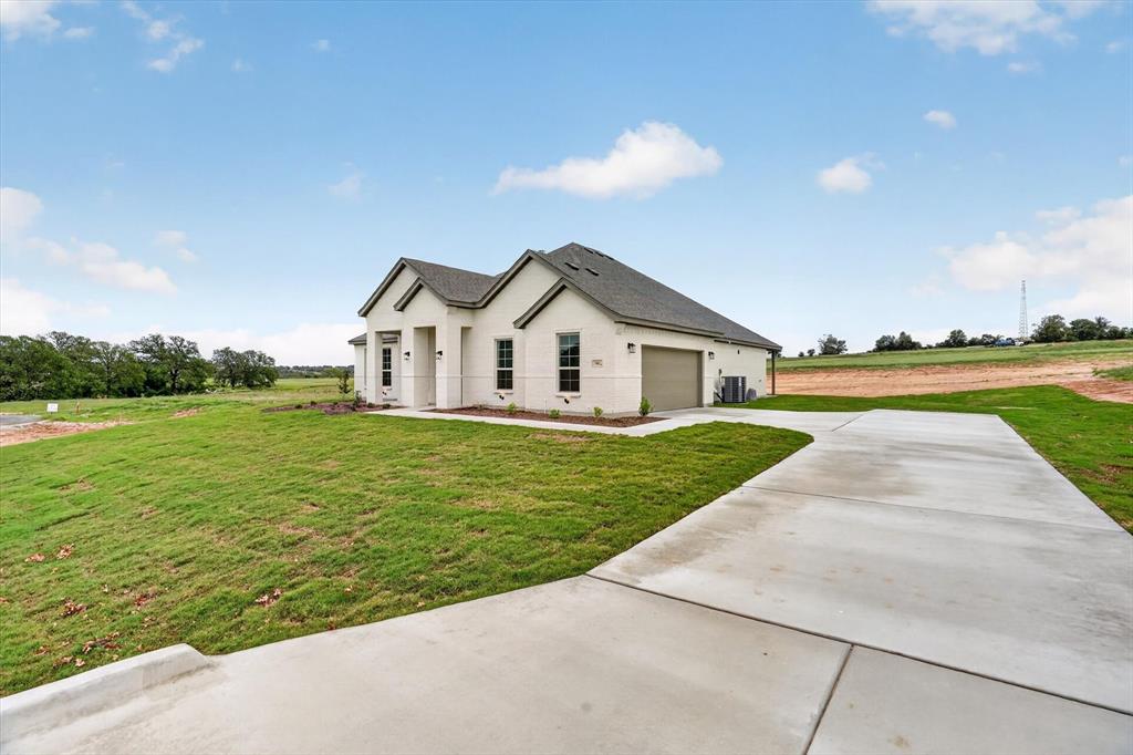 504 Clifton Court Springtown, TX 76082 - Photo 2 of 36 Contemporary stucco exterior with a multi-gabled roofline, an attached two-car garage, and a concrete driveway