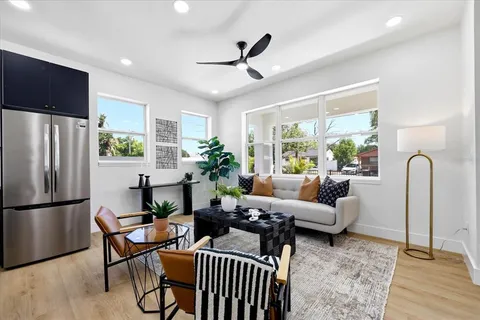a living room with furniture a large window with wooden floor