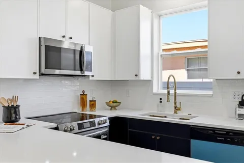 a kitchen with stainless steel appliances a sink a stove and microwave
