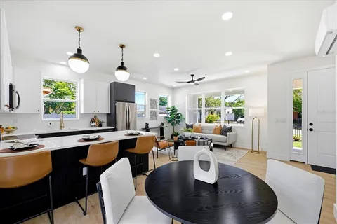 a dining room with wooden floor a chandelier a wooden table and chairs