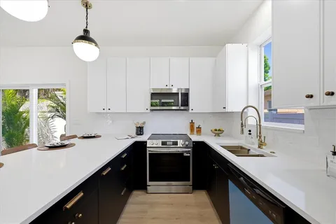 a kitchen with a sink and a stove top oven