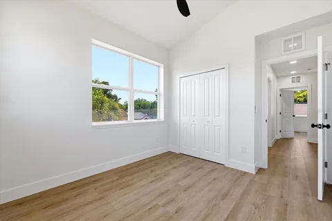 a view of a hallway with wooden floor and a window