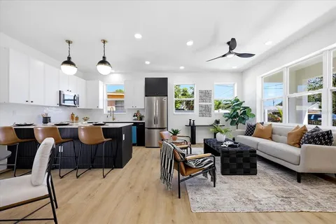 a living room with lots of furniture and kitchen view