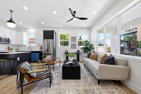 a living room with fireplace furniture and a large window