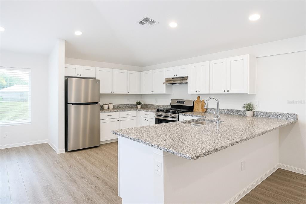 1145 South Apopka Avenue Inverness, FL 34452 - Photo 4 of 13 a kitchen with a refrigerator a sink and cabinets
