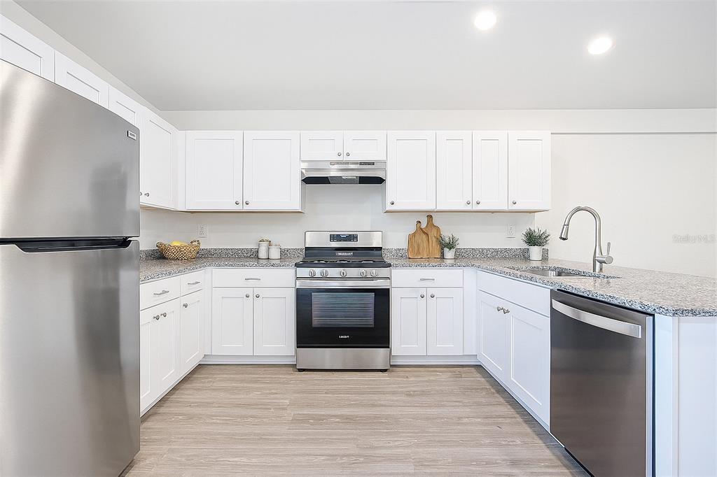 1145 South Apopka Avenue Inverness, FL 34452 - Photo 5 of 13 a kitchen with granite countertop white cabinets and stainless steel appliances