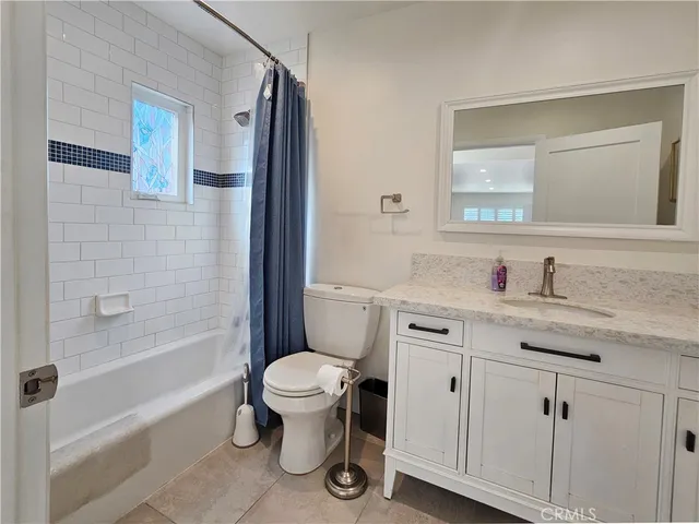 a bathroom with a granite countertop toilet sink and mirror