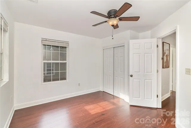 a view of a livingroom with a window and wooden floor