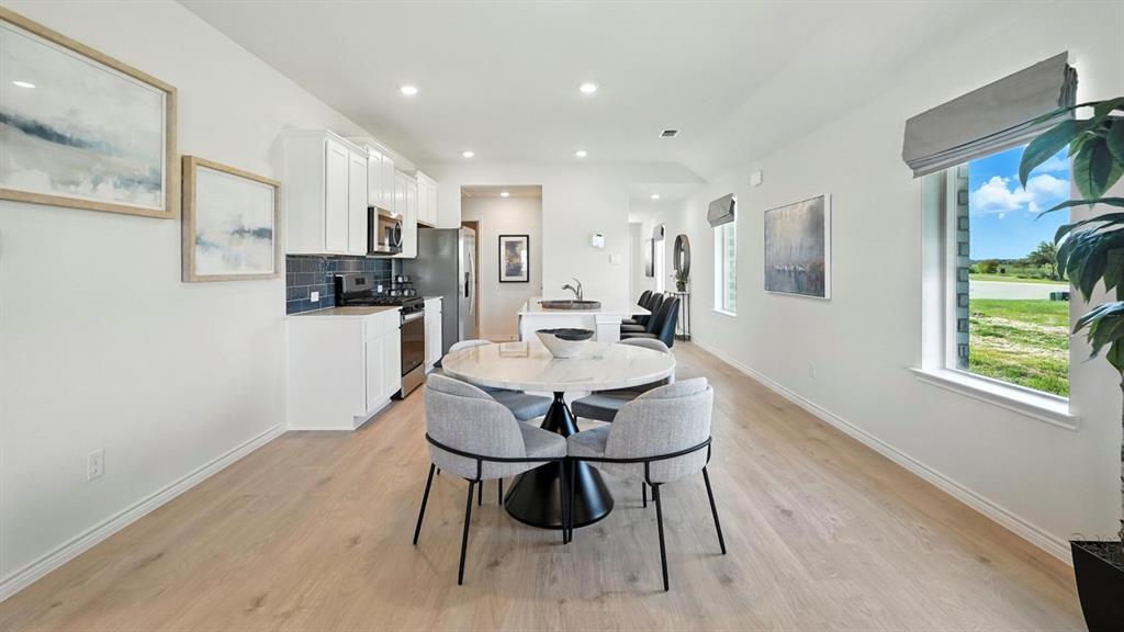 9820 Amalgam Street Aubrey, TX 76227 - Photo 13 of 40 a view of a dining room with furniture and wooden floor