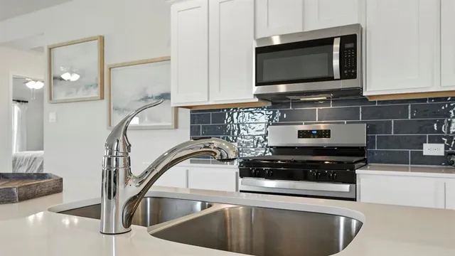 a kitchen with stainless steel appliances a stove a microwave and a sink
