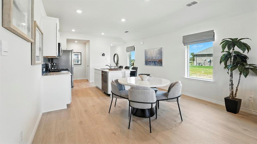 9820 Amalgam Street Aubrey, TX 76227 - Photo 2 of 40 a view of a dining room with furniture and a potted plant