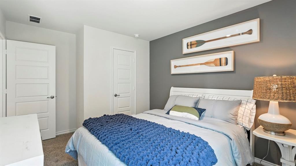 9820 Amalgam Street Aubrey, TX 76227 - Photo 25 of 40 a bedroom with a bed and a cabinets