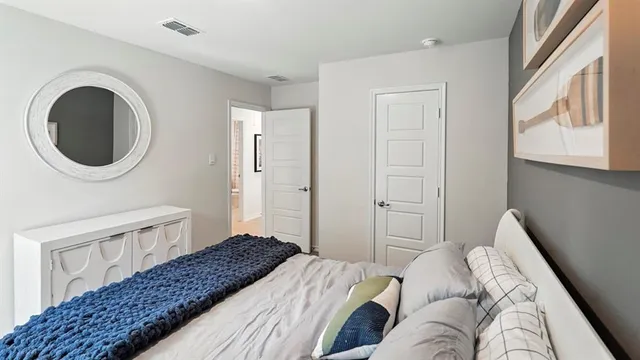 a bedroom with a bed a mirror and a window