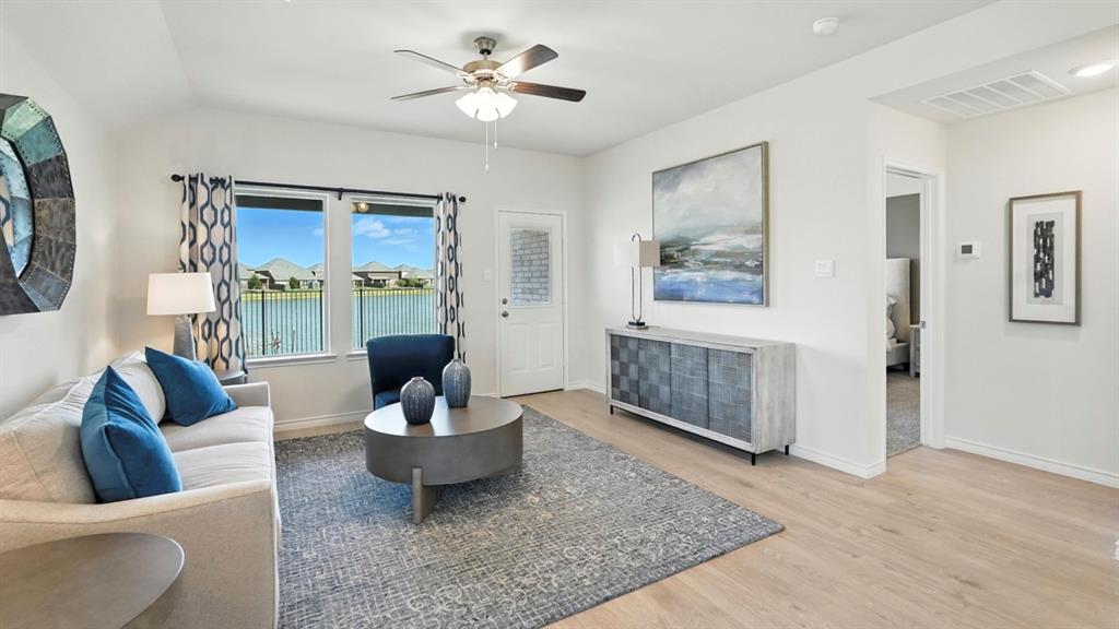 9820 Amalgam Street Aubrey, TX 76227 - Photo 8 of 40 a living room with furniture a ceiling fan a rug and a window