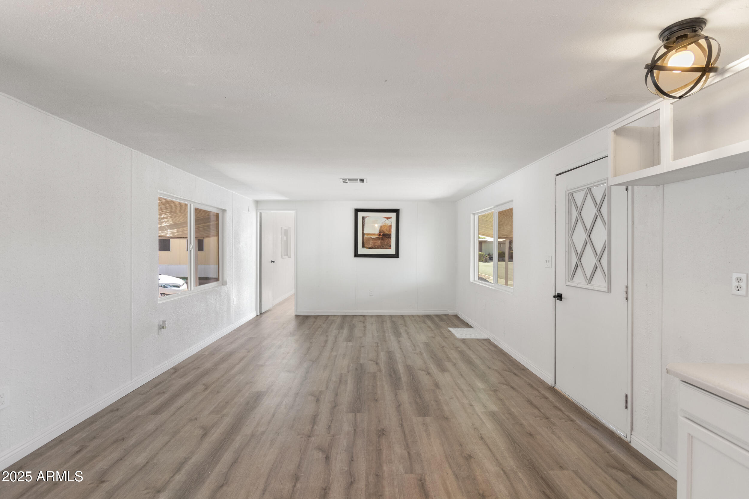 400 West Baseline Road, Unit 100 Tempe, AZ 85283 - Photo 13 of 46 a view of an empty room with wooden floor and a window