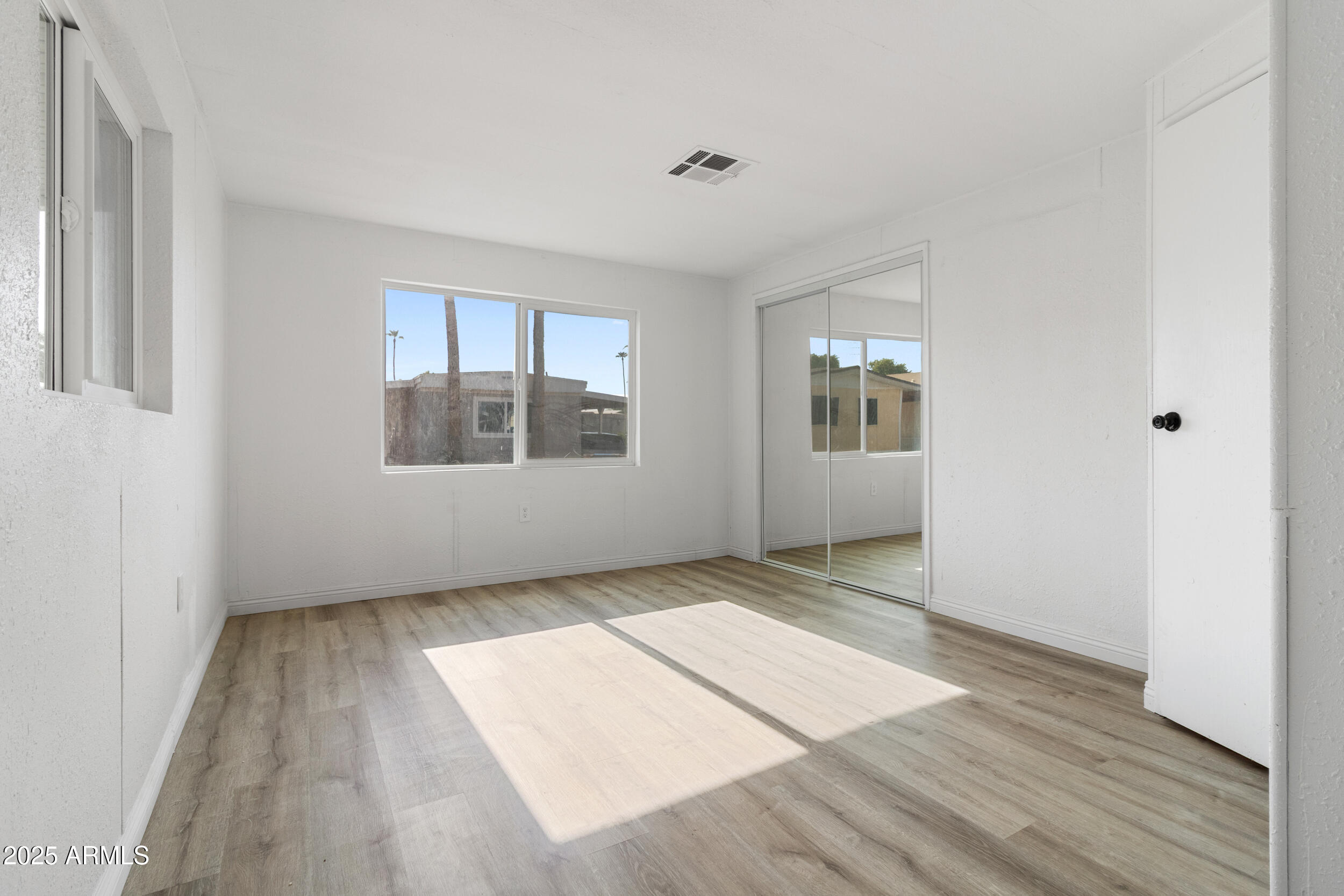 400 West Baseline Road, Unit 100 Tempe, AZ 85283 - Photo 17 of 46 an empty room with wooden floor and windows