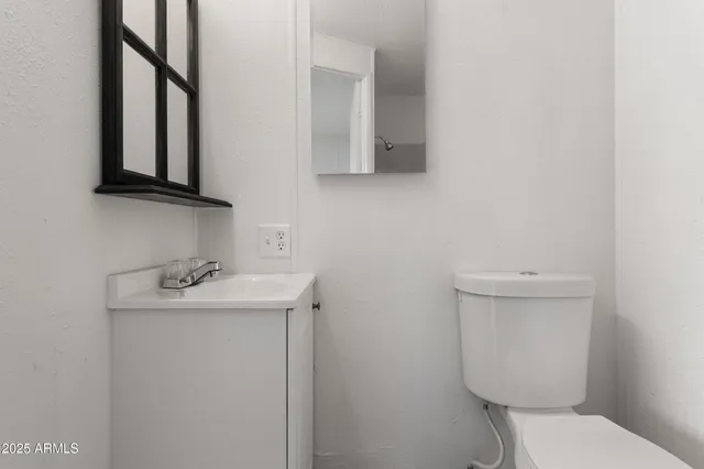 a bathroom with a toilet sink and mirror