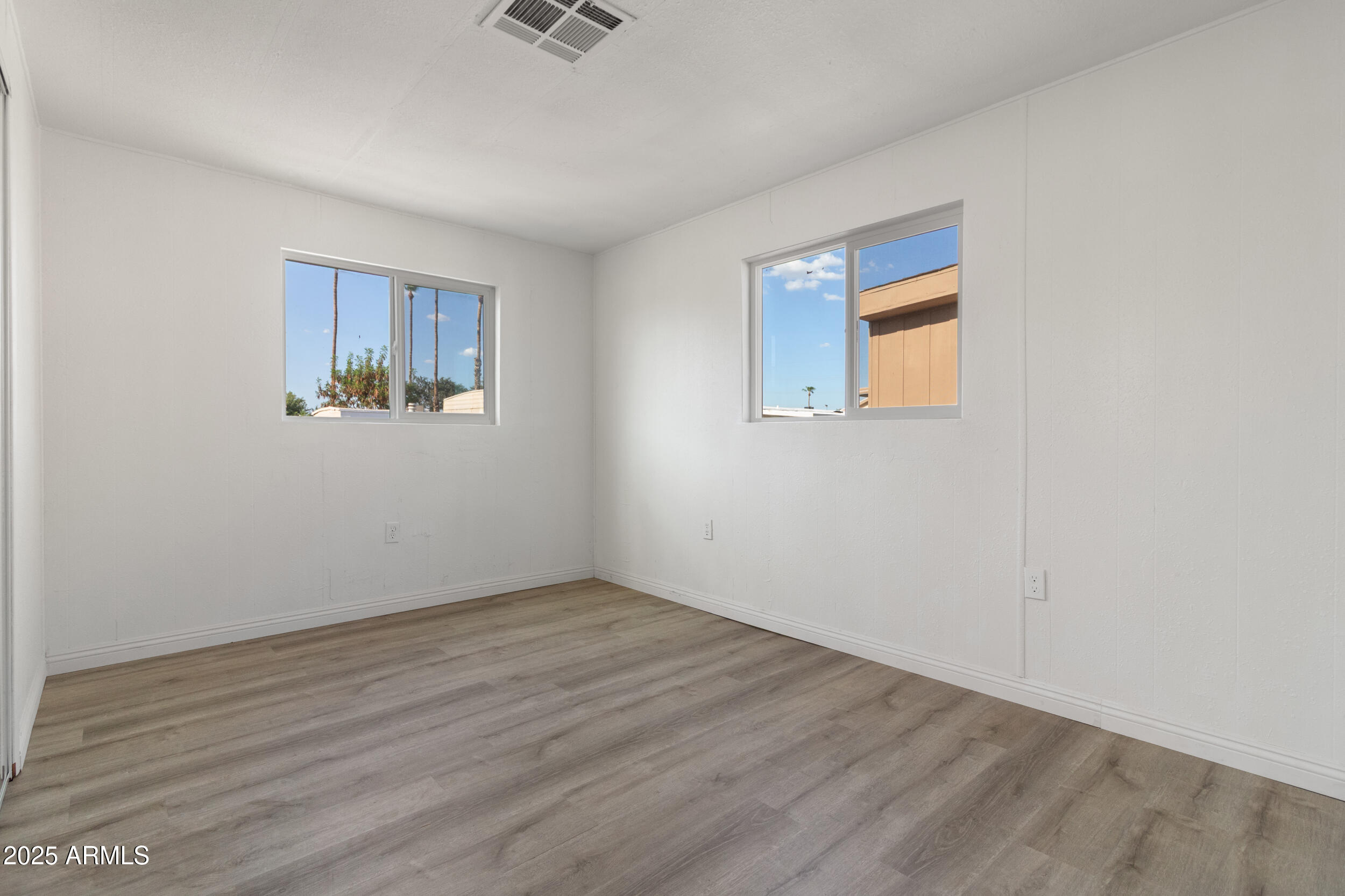 400 West Baseline Road, Unit 100 Tempe, AZ 85283 - Photo 22 of 46 a view of an empty room with wooden floor and a window