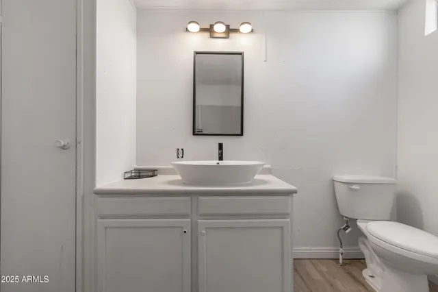 a bathroom with a toilet sink vanity and mirror