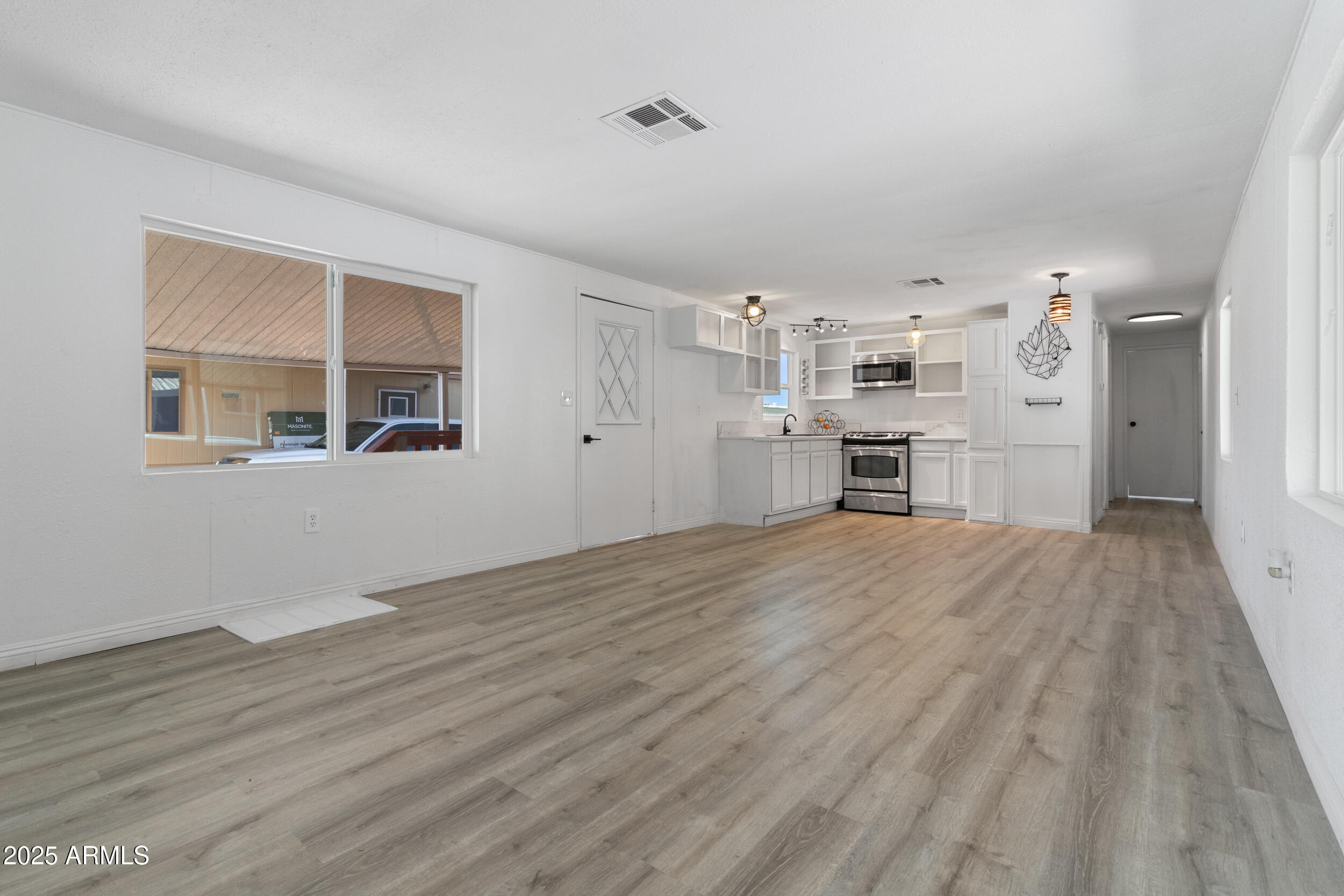 400 West Baseline Road, Unit 100 Tempe, AZ 85283 - Photo 9 of 46 a view of empty room with wooden floor and kitchen view