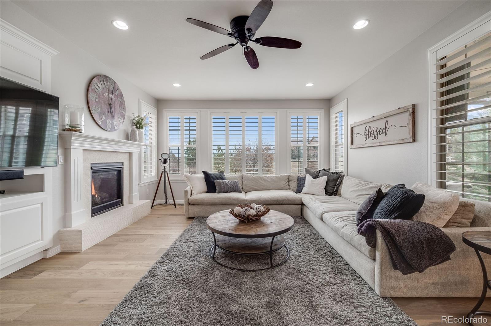 10702 Sundial Rim Road Highlands Ranch, CO 80126 - Photo 12 of 49 a living room with furniture a fireplace and a large window