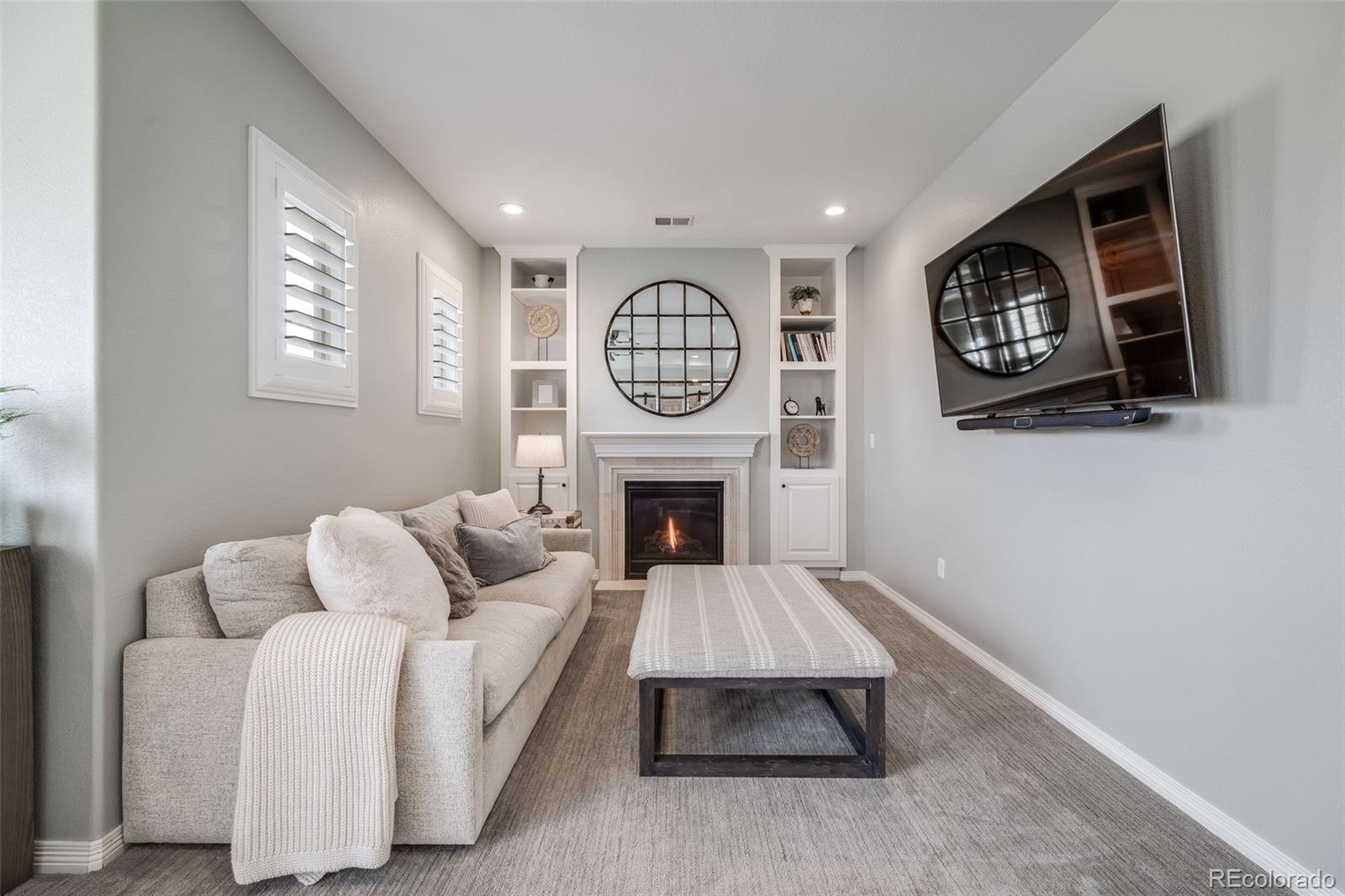 10702 Sundial Rim Road Highlands Ranch, CO 80126 - Photo 18 of 49 a living room with furniture a clock and a fireplace