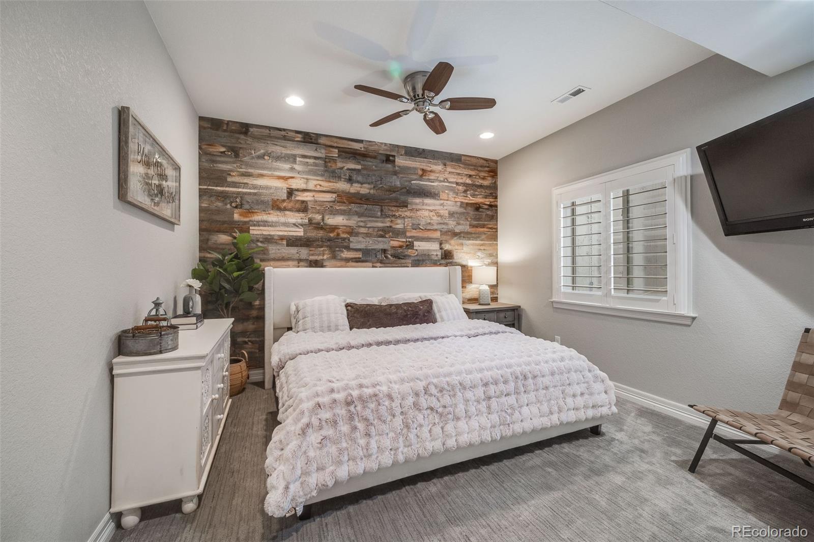 10702 Sundial Rim Road Highlands Ranch, CO 80126 - Photo 33 of 49 a bedroom with a bed and a flat screen tv