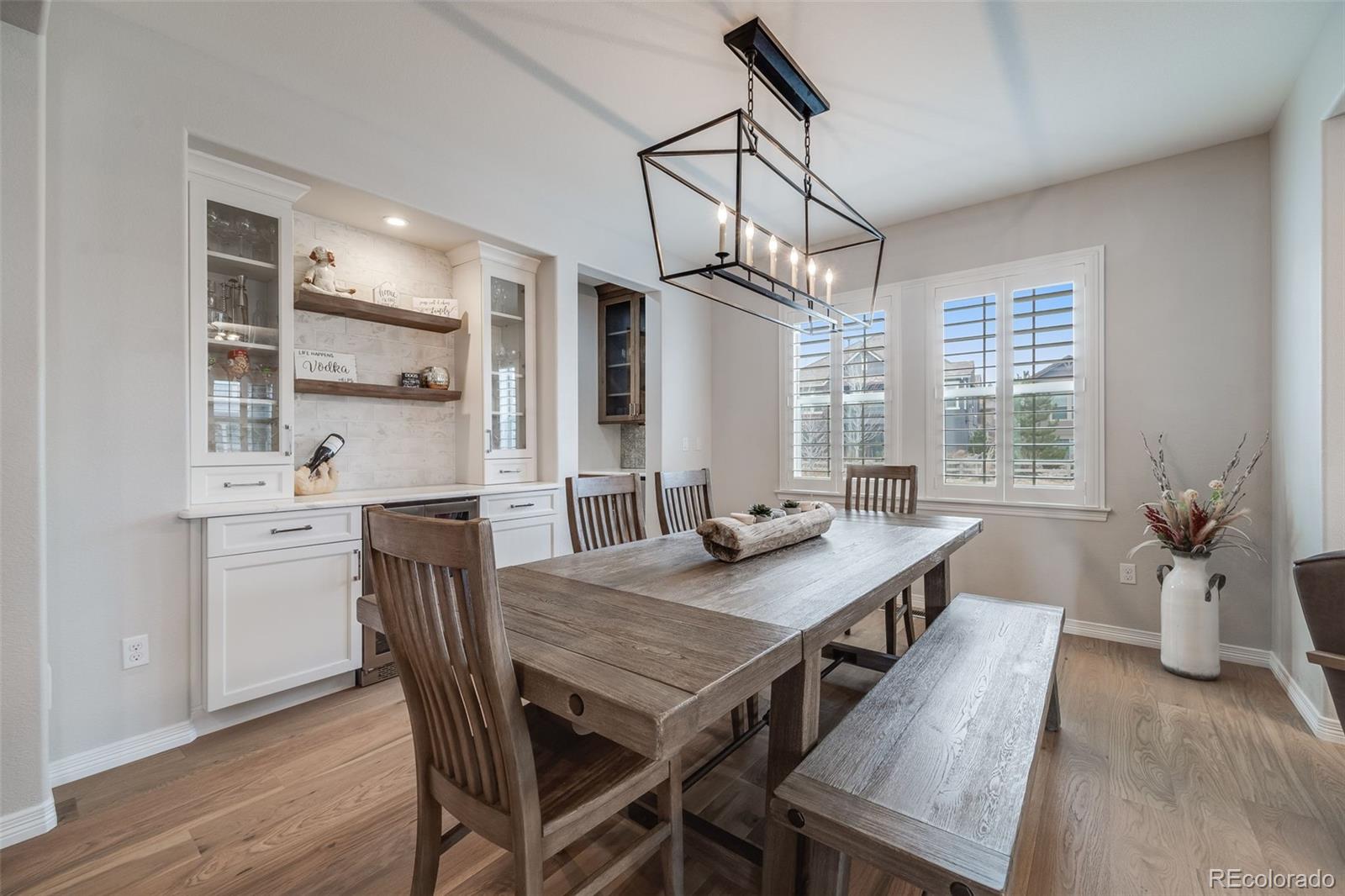 10702 Sundial Rim Road Highlands Ranch, CO 80126 - Photo 6 of 49 a view of a dining room and livingroom with furniture wooden floor a chandelier