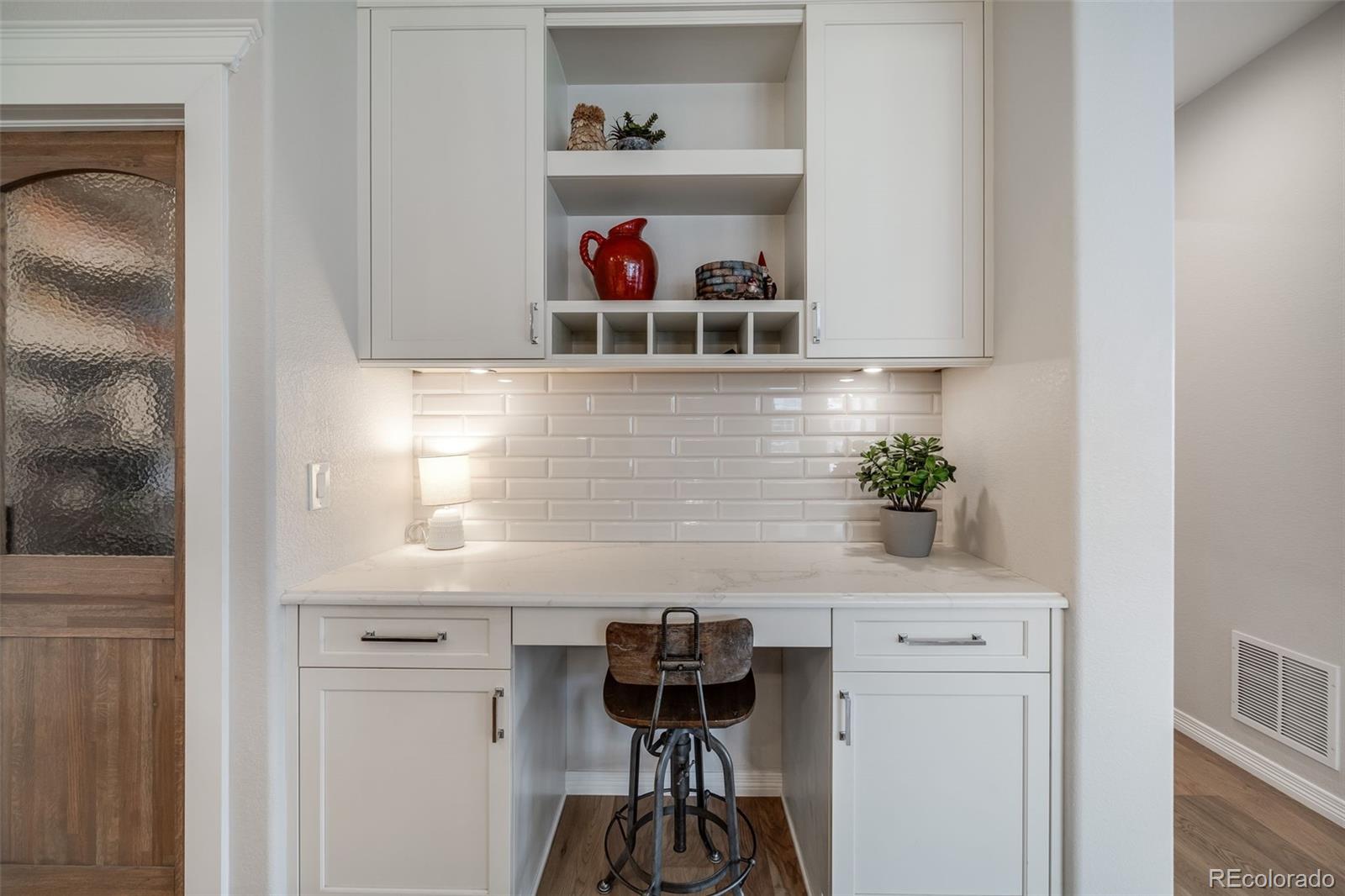 10702 Sundial Rim Road Highlands Ranch, CO 80126 - Photo 8 of 49 a view of a hallway with table and white cabinets