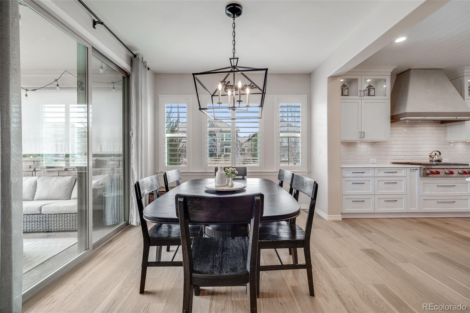 10702 Sundial Rim Road Highlands Ranch, CO 80126 - Photo 10 of 49 a dining room with furniture a chandelier and wooden floor