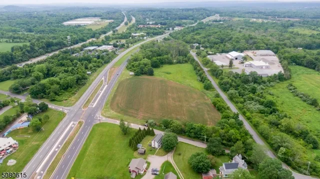 an aerial view of residential houses with outdoor space and trees