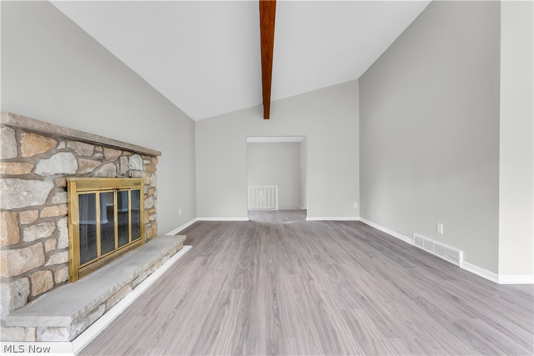 6190 Mill Road Broadview Heights, OH 44147 - Photo 6 of 36 Unfurnished living room with hardwood / wood-style flooring, a fireplace, and vaulted ceiling with beams