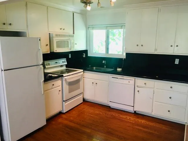a kitchen with white cabinets and white appliances
