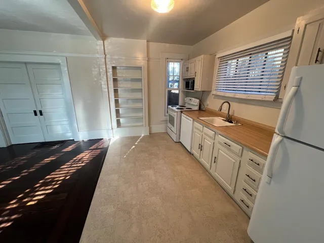 a kitchen with granite countertop sink stove and cabinets