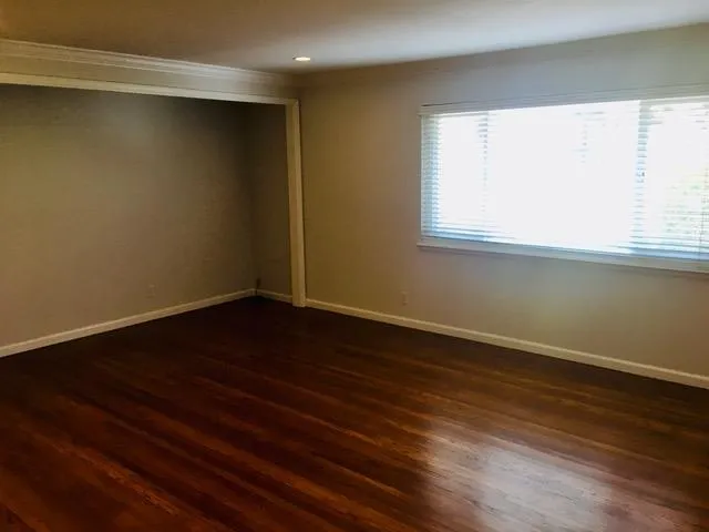 a view of a room with wooden floor and a window