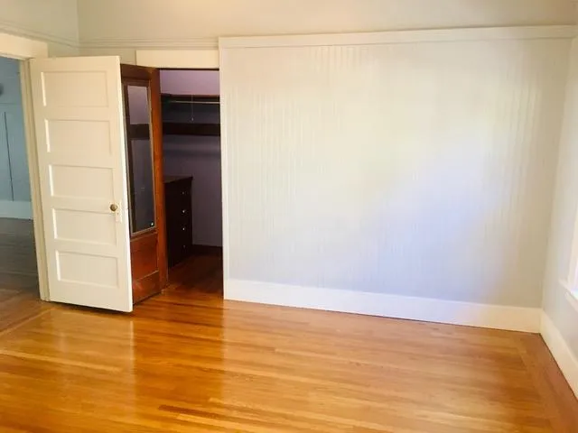 a view of an empty room with wooden floor
