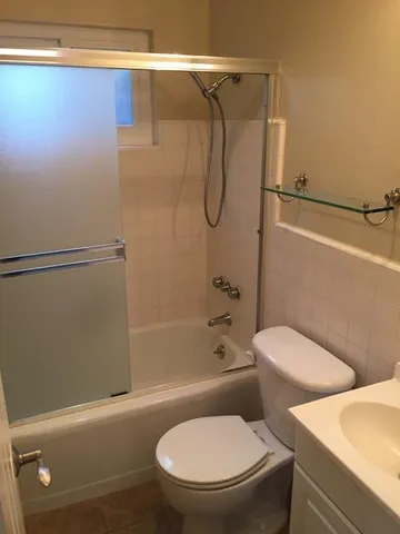 a white toilet and tub next to a bathroom sink
