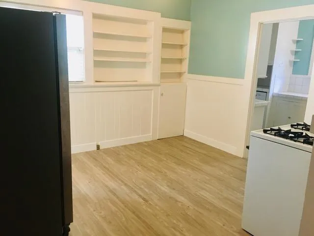 a view of a room with wooden floor and cabinet