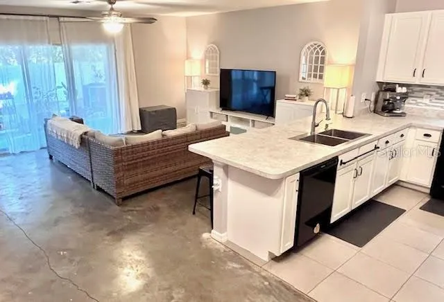 a living room with stainless steel appliances kitchen island granite countertop a sink and a stove top oven