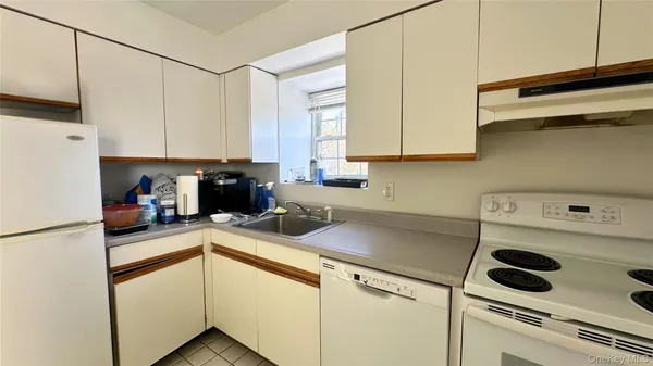 a kitchen with a refrigerator a stove a sink and cabinets