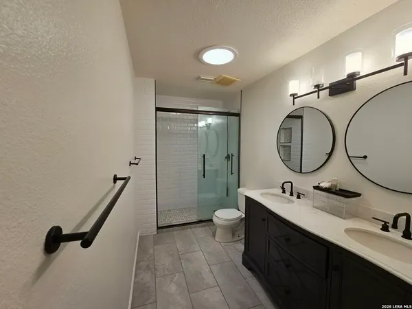 a bathroom with a double vanity sink mirror and toilet