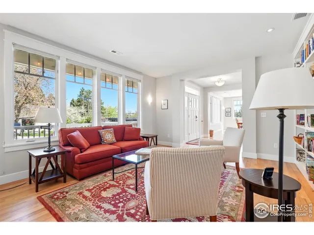 a living room with furniture a large window and a dining table