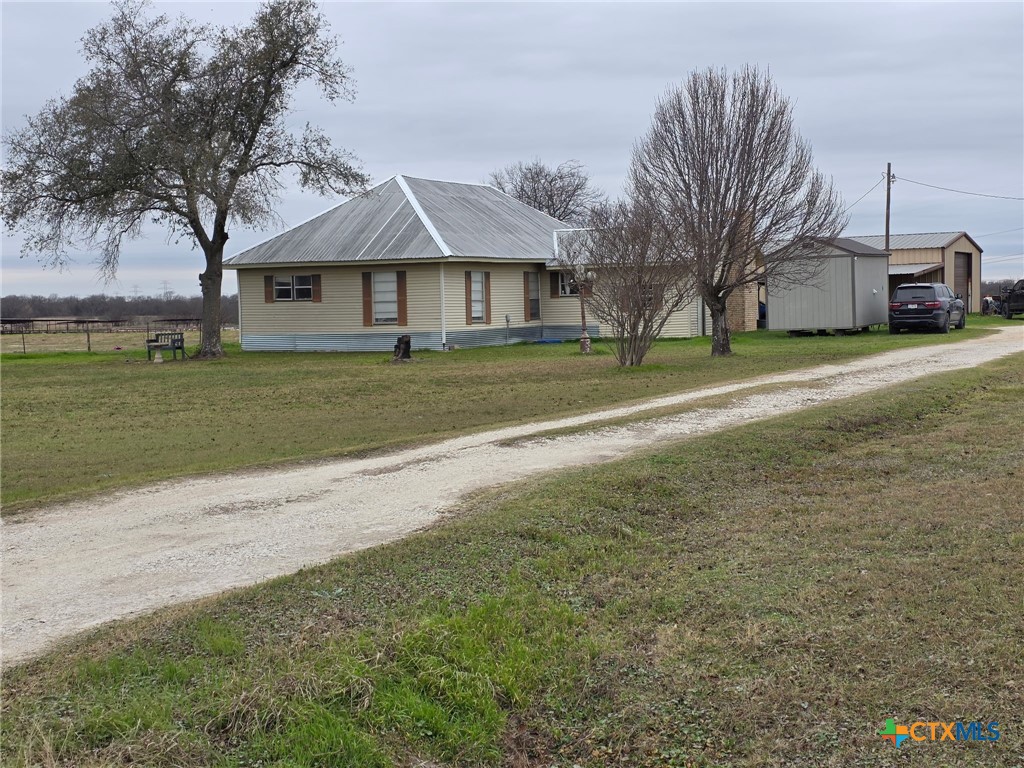 a front view of house with yard and trees all around